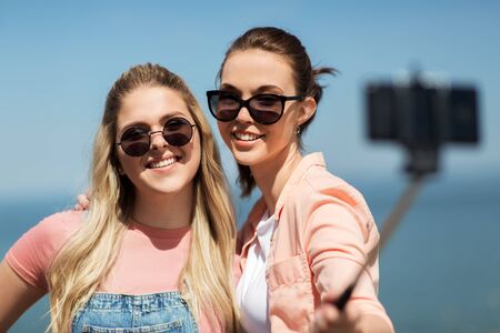 leisure and friendship concept - happy smiling teenage girls or best friends in sunglasses hugging...