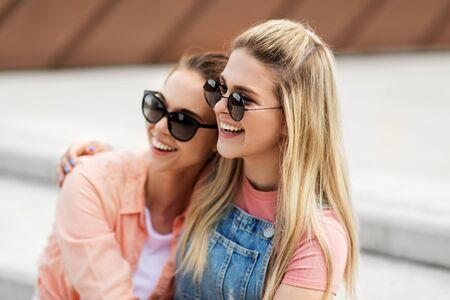 teenage girls or friends on city street in summerの写真素材