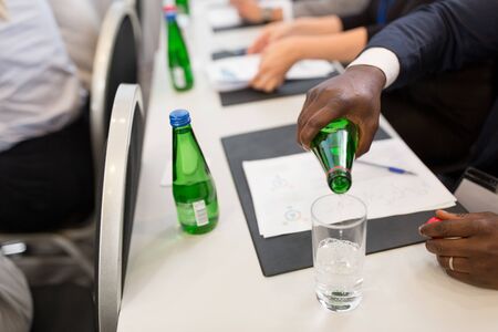 businessman pouring water to glass at conferenceの写真素材