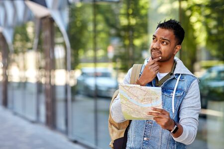 indian man traveling with backpack and map in city