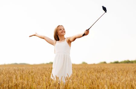 happy young girl taking selfie by smartphoneの写真素材