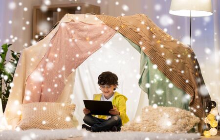 little boy with tablet pc in kids tent at homeの写真素材