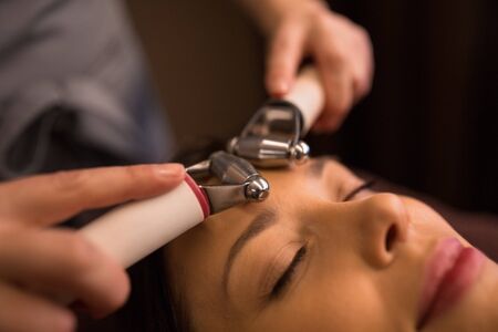 woman having hydradermie facial treatment in spaの写真素材