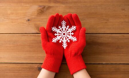 hands in red woollen gloves holding big snowflakeの写真素材