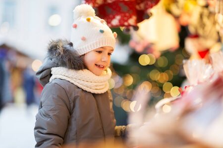 happy little girl at christmas market in winterの写真素材