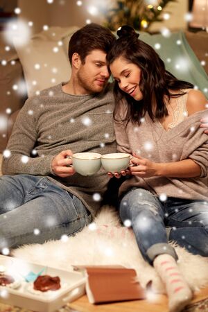 happy couple drinking hot chocolate on christmasの写真素材