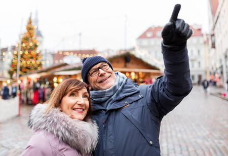 happy senior couple hugging at christmas marketの写真素材