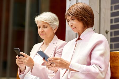 happy senior women with smartphones in cityの写真素材