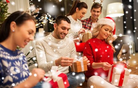 friends celebrating christmas and opening presentsの写真素材