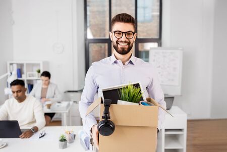 Happy smiling male office worker with personal stuff