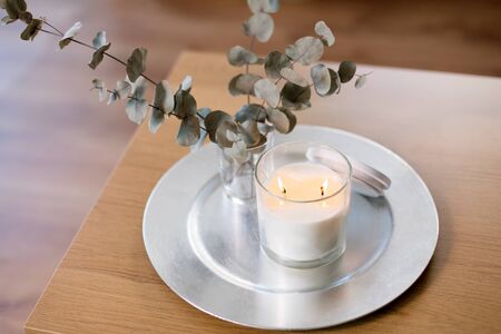 Burning fragrance candle and flower bunch at cozy homeの写真素材