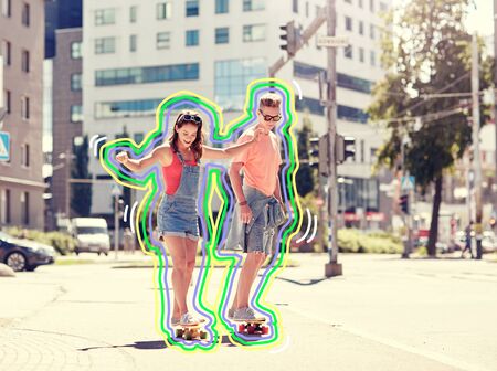 teenage couple riding skateboards on city streetの写真素材