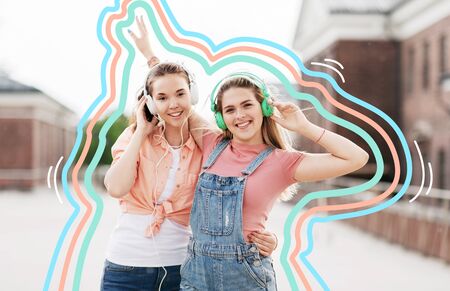 leisure, music and friendship concept - happy smiling teenage girls or best friends in headphones hugging on city street in summer with glowing linesの写真素材