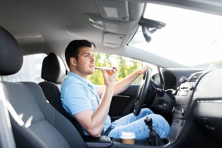 transport, vehicle and people concept - smiling man or driver driving car and recording message...