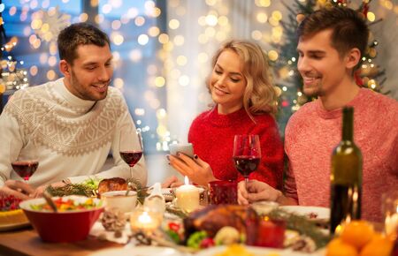friends with cellphone celebrate christmas at homeの写真素材