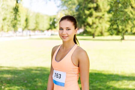 woman at running marathon with badge number