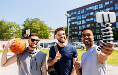 happy men taking selfie at basketball playgroundの写真素材