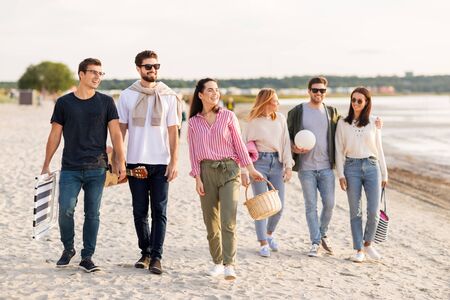 happy friends walking along summer beachの写真素材