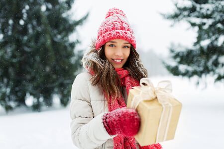 happy young woman with christmas gift in winterの写真素材