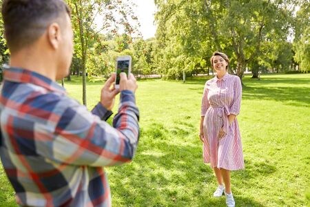 couple photographing by smartphone in park