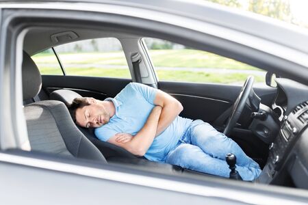 tired man or driver sleeping in car