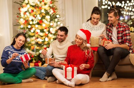 friends celebrating christmas and opening presentsの販売画像