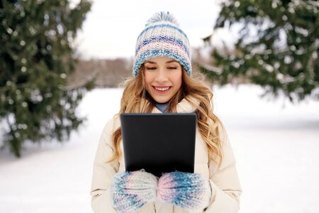 woman with tablet computer outdoors in winter