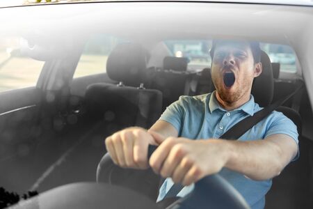 transport, vehicle and driving concept - tired sleepy man or car driver yawningの写真素材