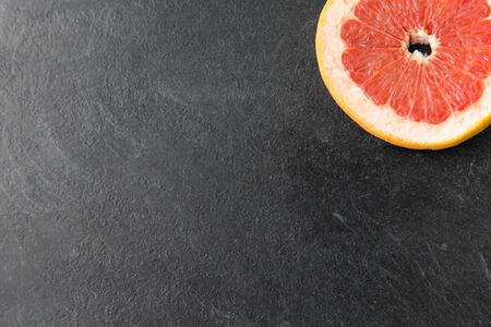 close up of fresh juicy grapefruit on slate boardの写真素材