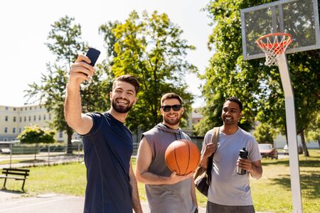 happy men taking selfie at basketball playgroundの写真素材