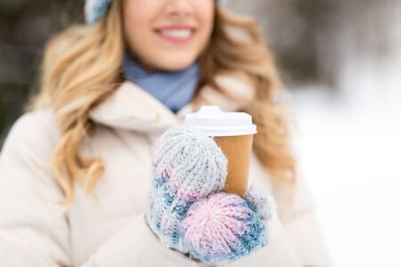 happy woman drinking coffee outdoors in winterの写真素材