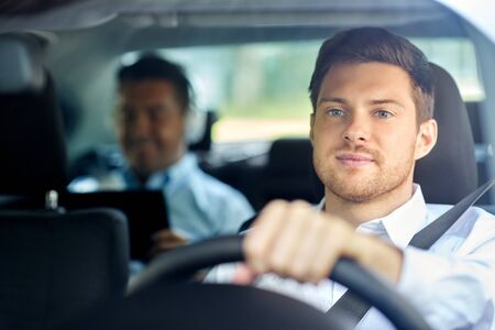 transport, people and taxi concept - male driver driving car with passenger