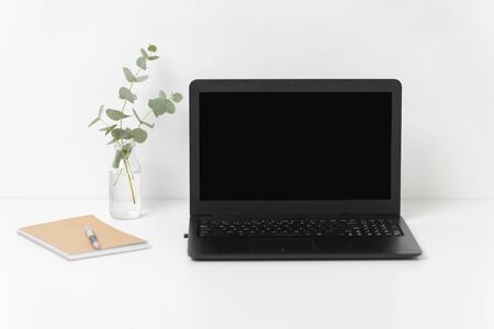 laptop with black screen on white office tableの写真素材
