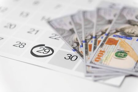 shopping, sale and marketing concept - close up of black friday date on calendar and moneyの写真素材