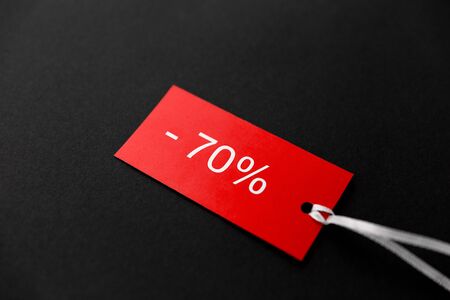 shopping, sale and outlet concept - red tags with discount signs on black backgroundの写真素材