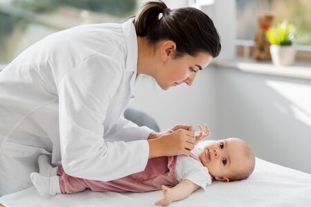 female pediatrician doctor with baby at clinic