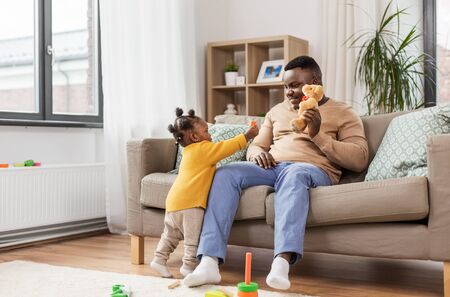 african american father playing with baby at homeの写真素材