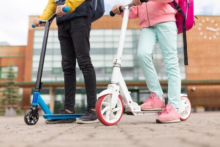 school children with backpacks and scootersの写真素材