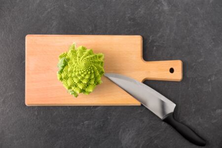 romanesco broccoli and knife on cutting boardの写真素材