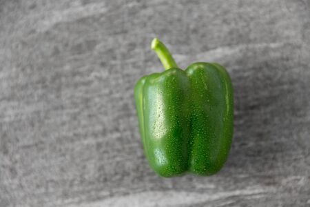 vegetable, food and culinary concept - close up of green pepper on slate stone backgroundの写真素材
