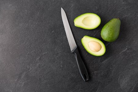 avocados and knife on slate stone backgroundの写真素材