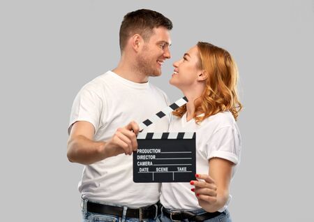 happy couple in white t-shirts with clapperboard