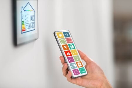 hand with smart home icons on smartphone screenの写真素材