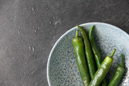 close up of green chili peppers in bowlの写真素材