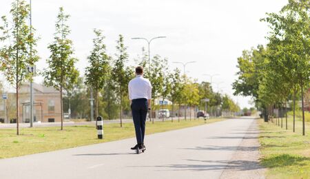 young businessman riding electric scooter outdoors