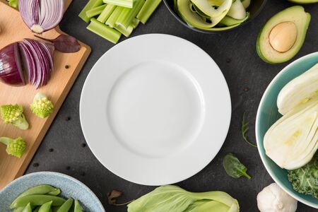 different green vegetables and white empty plateの写真素材