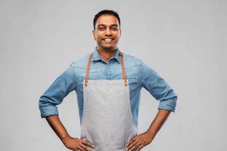 Smiling indian barman, waiter or salesman in apronの写真素材