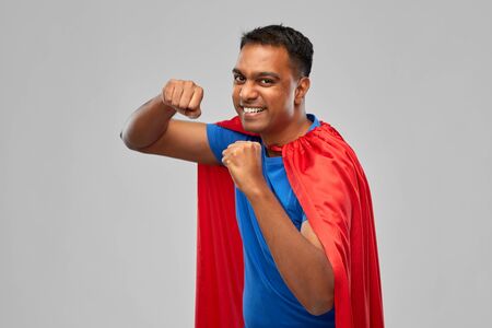 indian man in superhero cape makes winning gestureの写真素材