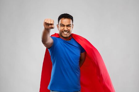 indian man in superhero cape flying over greyの写真素材
