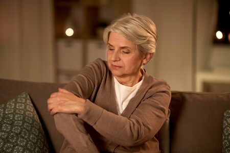 senior woman suffering from pain in hand at home
